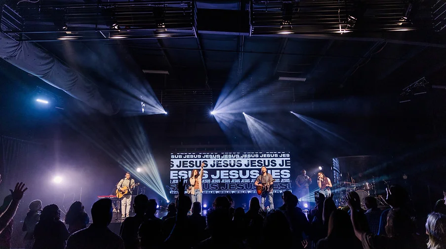 Warehouse Community worship night with the band leading under stage lights